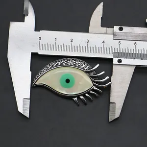 Detailed measurement of a silver evil eye pendant showing a 4.5cm size on a caliper