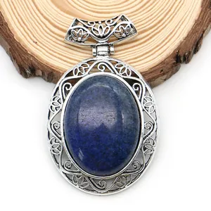 Detail of silver hollowed oval blue agate pendant with vintage engraving on wood base