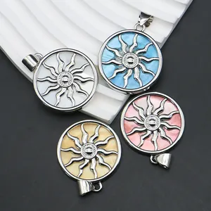 Round sun totem shell pendants in four colors on a wavy display with silver metal hooks