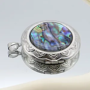Macro detail of oval locket pendant featuring abalone shell inlay and vintage floral relief