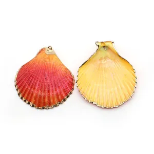 Dettaglio di ciondoli in conchiglia con bordi placcati oro e texture naturale arancione