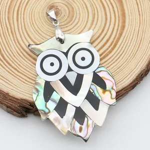 Détail du pendentif hibou fait main avec incrustations de nacre et fermoir argenté