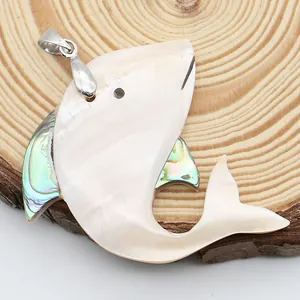 Détail d'un pendentif poisson en nacre blanche et coquille d'abalone sur bois naturel