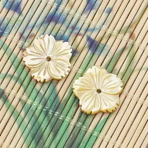 Vue macro de perles en nacre en forme de fleur avec des détails de pétales sculptés