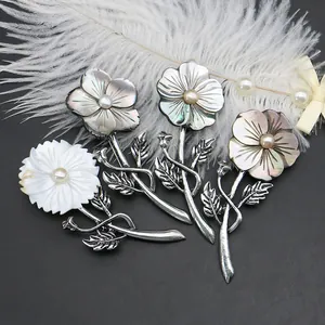 French shell flower brooches with natural mother of pearl and pearls on black background