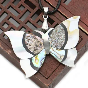 Détail macro du pendentif papillon fait main en nacre naturelle et nacre d'abalone