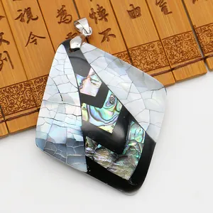 Vue macro d'un pendentif losange en nacre avec texture d'abalone irisée sur bambou