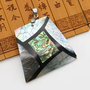 Gros plan d'un pendentif trapèze en nacre d'abalone avec texture naturelle sur bambou