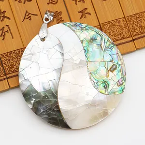 Détail du pendentif en nacre d'abalone avec motif de vagues Yin Yang sur bambou ancien