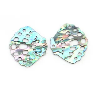 Macro detail of iridescent scallop shell pendants with geometric hollow-out pattern