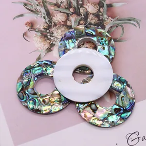 Détail de pendentifs ronds évidés en nacre naturelle et mosaïque de nacre d'ormeau