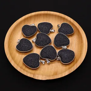 Set of 9 heart-shaped natural lava rock pendants with silver-plated edges on wood tray