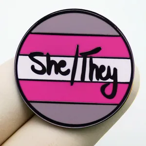 Στρογγυλή καρφίτσα She/They με ροζ, λευκές και γκρι ρίγες για την ταυτότητα φύλου