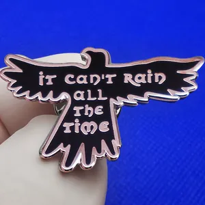 Enamel black crow brooch with 'IT CAN'T RAIN ALL THE TIME' quote and rose gold metal edges
