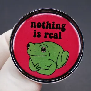 Funny green frog badge with 'nothing is real' text on pink metal alloy brooch pin