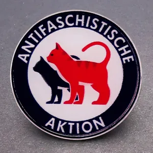 Close-up of Antifascist Action round enamel pin featuring red and black cats