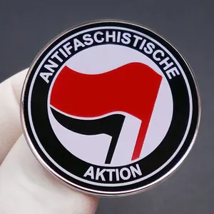 Primer plano de la insignia Acción Antifascista con dos banderas y bordes metálicos