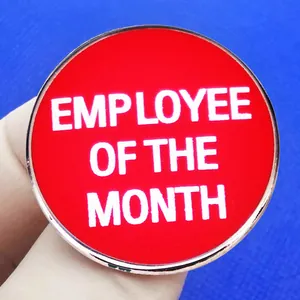 Employee of the month enamel pin with red finish and silver edge shown held in hand