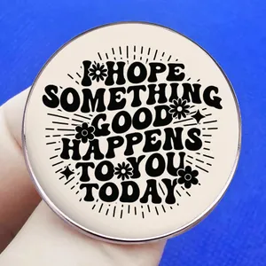 Inspirational round enamel pin with motivational text on bright blue background