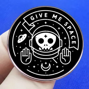 Give Me Space astronaut skull enamel pin with UFO and stars on a black background