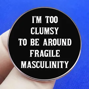 Round black badge with I'm Too Clumsy To Be Around Fragile Masculinity slogan