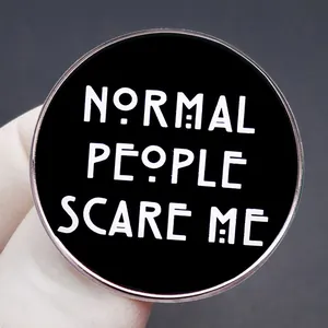 Normal People Scare Me badge featuring black enamel, silver border, and bold white text