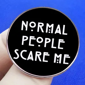 Black round enamel pin badge with Normal People Scare Me text in white lettering