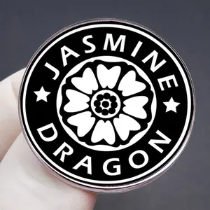 Avatar White Lotus enamel pin with Jasmine Dragon text shown in a hand-held close-up