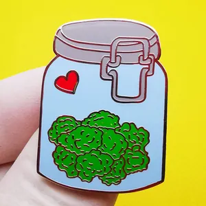 Cute enamel jar pin with green herb flowers and red heart on high-contrast background