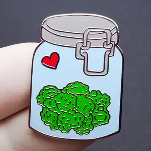 Cute enamel pin shaped like a weed jar with green buds and red heart on black background