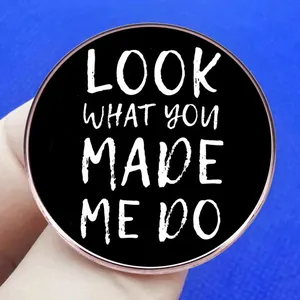 Black round brooch pin featuring Look What You Made Me Do lyrics in white font