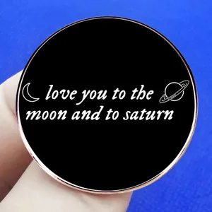 Black enamel brooch with 'love you to the moon and to saturn' text and celestial motifs