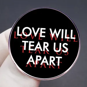 Spilla Joy Division Love Will Tear Us Apart in metallo nero tra le dita