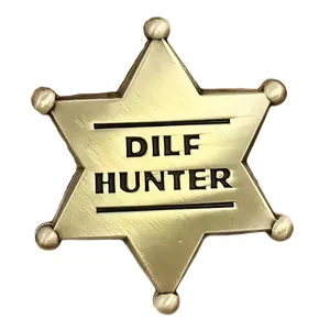 Détail macro du badge étoile doré avec gravure DILF HUNTER et texture en métal brossé