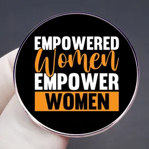 Empowered Women Empower Women feminist brooch in black metal alloy with white orange text