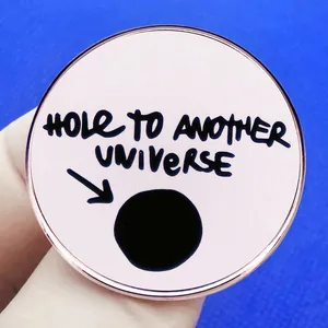 Pink enamel pin featuring Hole to Another Universe slogan with a black hole design