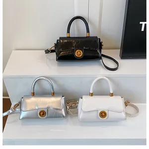Détail de mini sacs bandoulière avec fermoir anneau et cuir texturé en trois couleurs