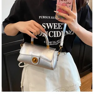 Détail du sac à bandoulière argenté métallisé avec fermoir rotatif doré élégant