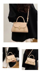 Detail view of stylish beige handbag featuring elegant gold twist lock and textured panels
