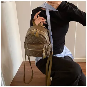 Close-up of olive green mini backpack with quilted diamond stitching and gold zippers
