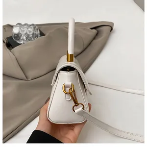 Vue détaillée du petit sac carré blanc avec texture cuir fin et garnitures métalliques dorées