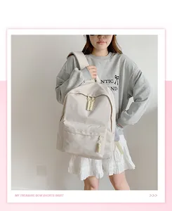 Detailed view of beige nylon backpack with unique knotted rope zipper and large capacity
