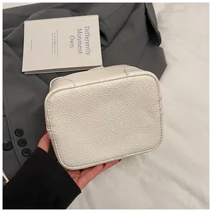Detail view of white lychee grain leather handbag base with reinforced stitching
