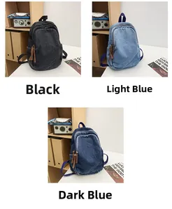 Detail view of denim backpacks in black, light blue, and dark blue with leather zipper pulls