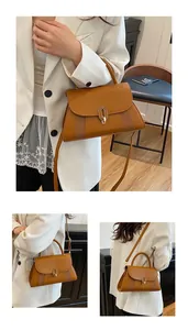 Close-up of brown crossbody bag featuring golden oval metal lock and side woven texture