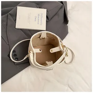 Internal view of a white bucket bag with pebble leather texture and magnetic closure