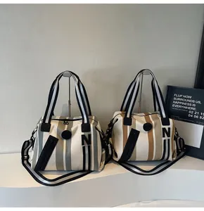 Detail view of striped woven tote bags with front zippers and detachable shoulder straps