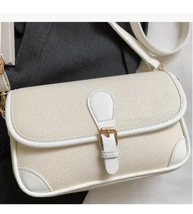 Détail du sac bandoulière en cuir grainé blanc cassé avec boucle dorée en métal