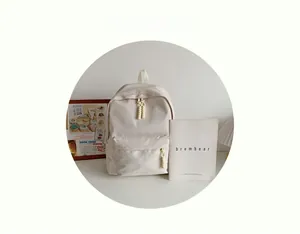 Detail of a minimalist beige waterproof nylon backpack with woven knot zipper pullers