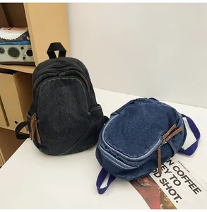 Detail of denim backpacks with metal zippers and leather pullers in blue and black